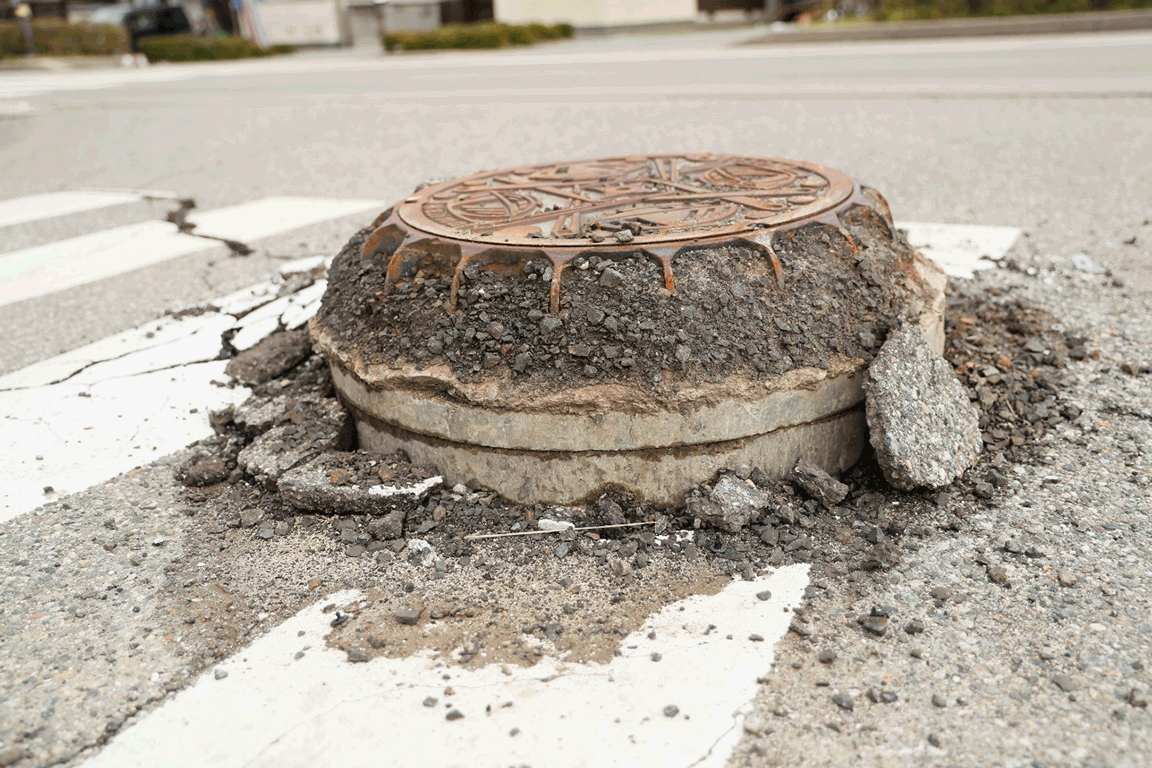 町中のいたるところで、液状化によりマンホールが浮き上がっていた画像