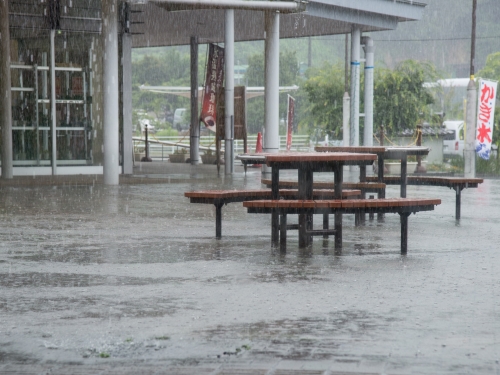 大雨で公共の広場が浸水しベンチの足が雨水に浸かっている